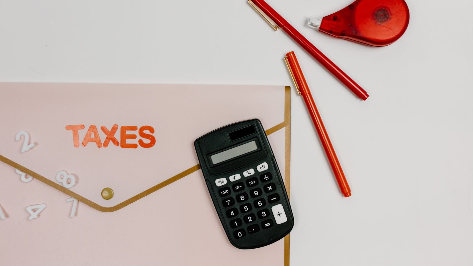 A calculator and tax documents on a desk
